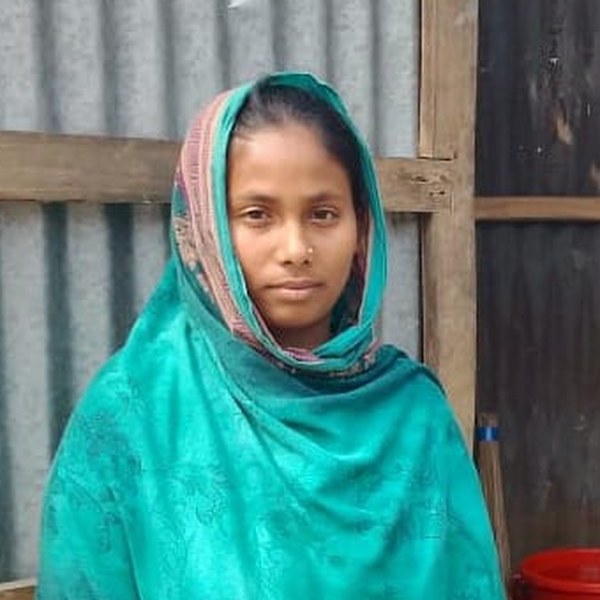 A Health Leaders participant stands outside her home, looking towards the camera.
